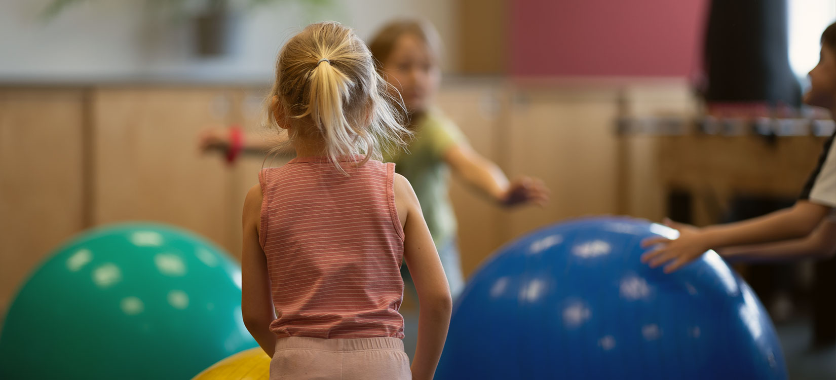 Kinder spielen mit großen Bällen